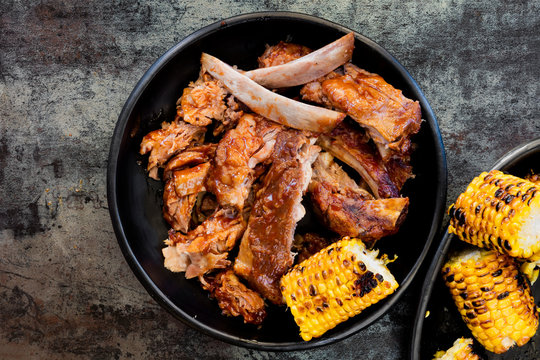BBQ Pork Ribs with Grilled Sweetcorn Top View over Slate