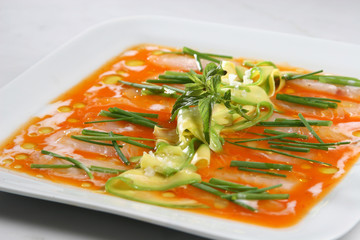salmon carpaccio, thin slices of salmon seasoned with olive oil and avocado