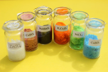 Bottles with colored metal salts that are used in analytical chemistry.