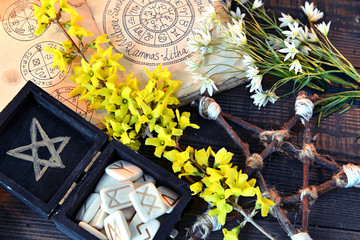 Box with runes, pentagram and flowers on green witch table.