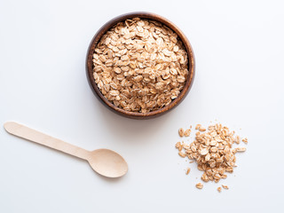 Zutat für ein gesundes Frühstück, frische Haferflocken in einer Holzschüssel auf einem weißen Hintergrund, Flat lay, Ballaststoff