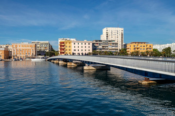 Obraz premium People cross the city bridge in Jazine bay in the town Zadar on a sunny day, Croatia