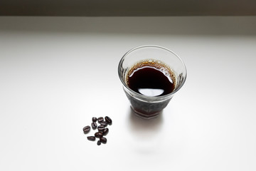 アイスコーヒーとコーヒー豆の白背景でのイメージ写真