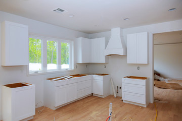 Interior design construction of a kitchen with cabinet maker installing custom