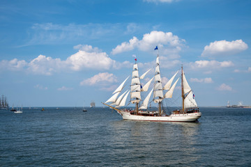 Fototapeta na wymiar Antique tall ship, vessel leaving the harbor of The Hague, Scheveningen under a sunny and blue sky.