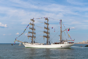 Antique tall ship, vessel leaving the harbor of The Hague, Scheveningen under a sunny and blue sky