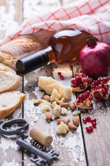 Set of wine rose, cheese and fresh natural pomegranate on a wooden table.