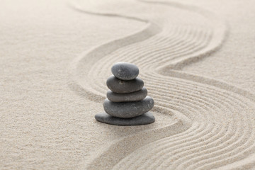 Fototapeta na wymiar zen stones piled on raked sand with copy space for your text