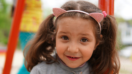 Portrait of Happy Smiling Child Girl Playing at Playground in Summer