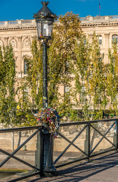 France, Paris, 1st arrondissement, Le Louvre at the Quai Francois Mitterrand and love locks on a lamp post of the Pont des Arts