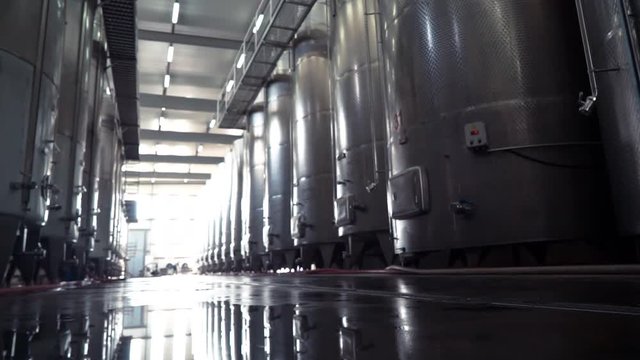 Large stainless steel wine distilling tanks. Silos for wine and beer fermentation . Steel barrels for fermentation of wine in winemaker factory .