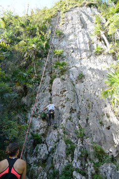 Cuba, Pinar del rio, Vinales, a man is climbing on limestone cliff