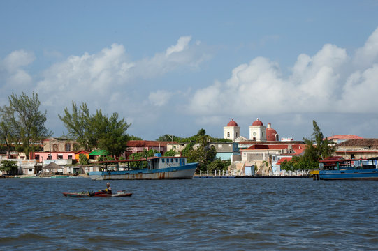 Cuba, Holguin area, the church and city of GIBARA from the sea where a fisherman stands in a very basic boat