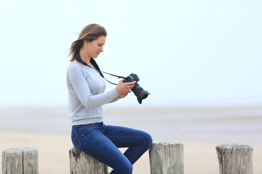 Young woman taking pictures at the beach