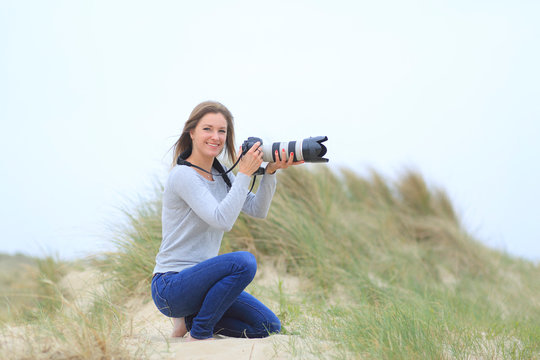 Young woman taking pictures at the beach