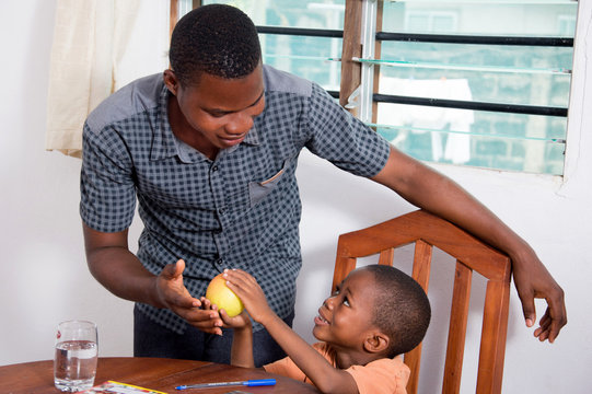 This child shows that apple to his father because he wants to eat it.
