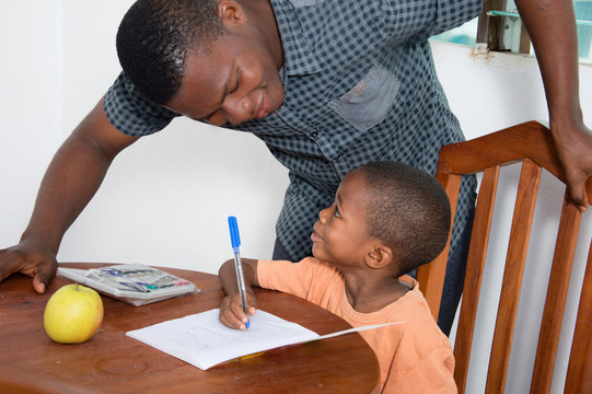 The teacher explains something to the schoolboy looking at his face