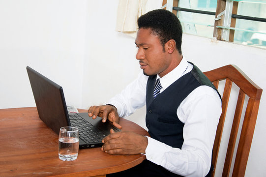 Young businessman sitting in his office and working on his laptop.