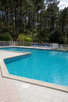 Outdoor in ground residential swimming pool in pine trees forest in Carcan France © OceanProd