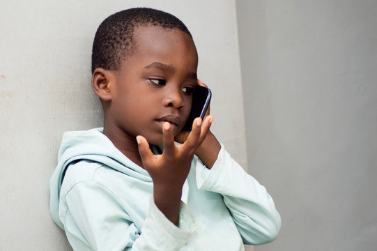 This Child Questions Himself With Gestures On The Phone With His Mother Or Father.