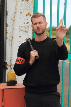 Security guard in front of a gate