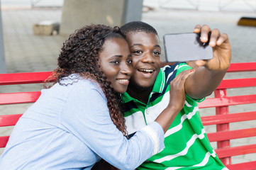 young couple takes pictures to mark their ride in the public square.
