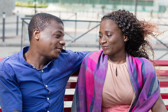 These young people sitting face to face, look  into their eyes with a smile.