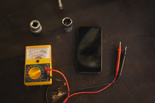 Motor testing multimeter and mobile phone at floor