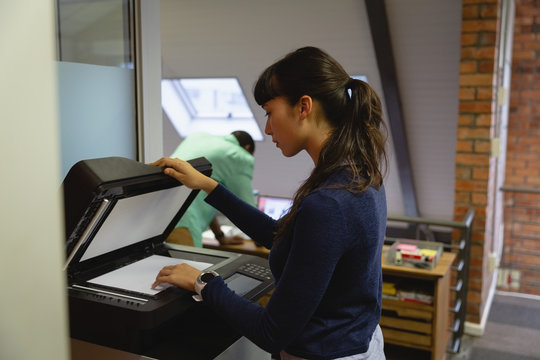 Businesswoman using Xerox machine in office