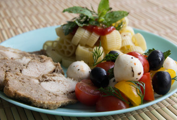 Chicken, horns and salad with tomatoes, mozzarella and olives
