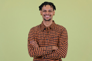 Fototapeta premium Happy young African man smiling with arms crossed