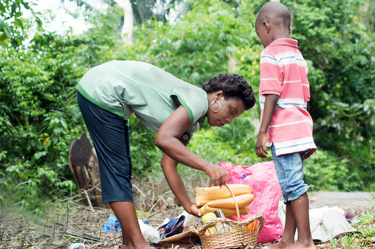 the young woman instead of food in a basket assisted by her child standing next to her.