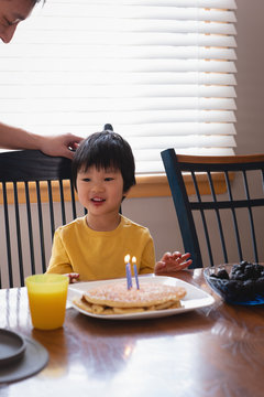 Father and son enjoying on dining table in kitchen