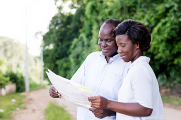 happy young couple in tourism, consult a regional map to find the right road.