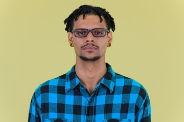 Face of young handsome African hipster man with eyeglasses