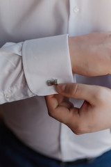 close up of a hand man how wears white shirt and cufflink.