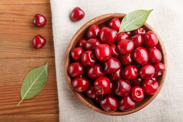 Fresh red sweet cherry in wooden bowl on wooden background. top view.