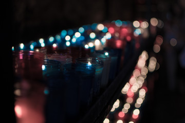 Fototapeta na wymiar A lot of colorful candles glowing in Covadonga, Asturias, Spain. Religious symbol of the spanish reconquest by King Pelayo