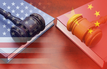 Trade tension or trade war between USA and China, financial concept.  Two gavels on legal books and...