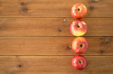 fruits, food and harvest concept - ripe red apples on wooden table