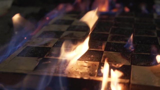 Burning chessboard close-up. Shooting a clip. Slow motion