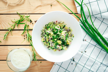 summer Russian cold soup okroshka with kefir on wooden background.