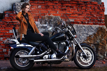 Fototapeta na wymiar Portrait of beautiful young woman posing with motorcycle