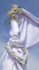 Tethered wattle white heart and full-bloom white calla lily on a arch 