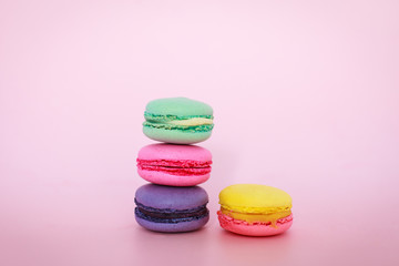 multicolored macarons on pink background