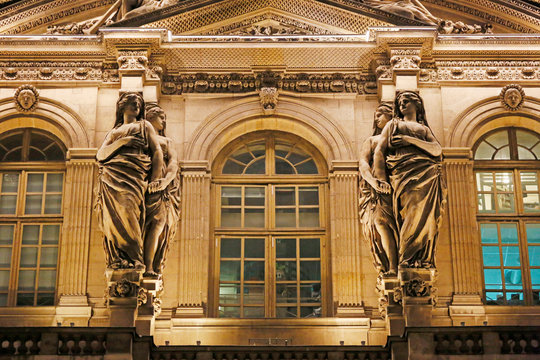 Paris. 1st district. Louvre Museum by night. Square courtyard. Facade of the Clock Pavilion. Architectural detail. Statue.