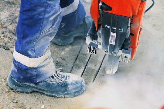 Worker with a grinder cutting the concrete floor