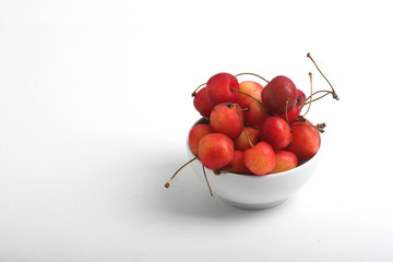 a bowl of cherries on white background