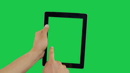 Pointing Finger Clicking On Left Device Screen with Green Background. Digital Tablet Green Screen. Use in any project that depicts finger, gesture, touchscreen and the like.
