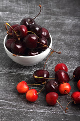 cherries in a bowl on black wooden background